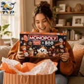 2026 Monopoly Burger King x Boo Collector Edition Board Game 2 A woman smiling while holding the Burger King x Boo Monopoly collector edition game box