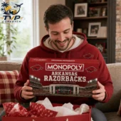 Arkansas Razorbacks Collector's Edition Monopoly Board Game 1 A man smiling while holding an Arkansas Razorbacks Monopoly collector edition board game from Tvpcomebackshop.