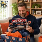 Monopoly Auburn Tigers Collector Edition Board Game 2 Man smiling while holding an Auburn Tigers Monopoly Collector Edition board game.