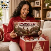 Monopoly Delta Sigma Theta Collector's Edition Board Game 2 Woman smiling while holding a Delta Sigma Theta Monopoly Collector Edition board game box.