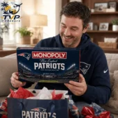 Man smiling while opening a New England Patriots Monopoly Collector Edition gift