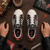 The Rolling Stones Its Only Rock N Roll Casual Air Force Shoes 1 Top-down view of The Rolling Stones branded Adidas sneakers on a wooden table.