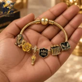 Gold snake chain bracelet with custom Alpha Phi Alpha charms held in a hand