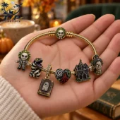 Beetlejuice themed gold charm bracelet held in hand