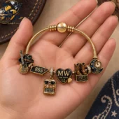 Customized gold tone charm bracelet featuring country music themed icons