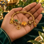 Lion King themed gold charm bracelet held in hand